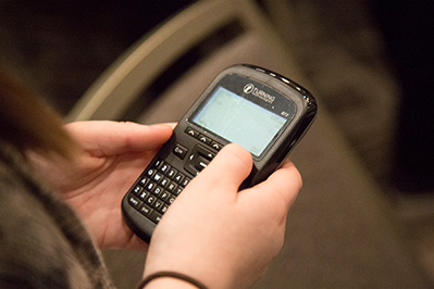A closeup of a handheld electronic voting device, held by two hands